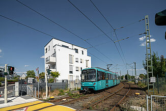 Widok ulicy na blok mieszkalny w Oberursel z przejeżdżającym tramwajem.