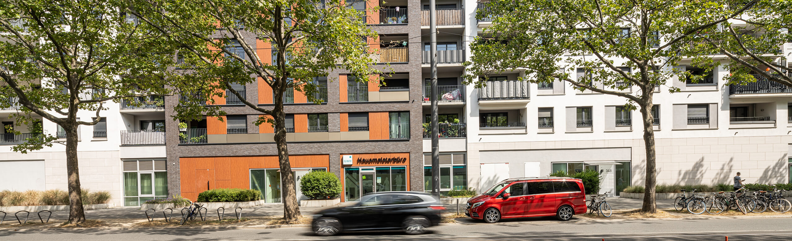 Front view of the Alea Quartier in Frankfurt with a passing car.